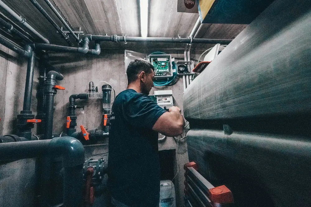 Technician working in a pool plant room
